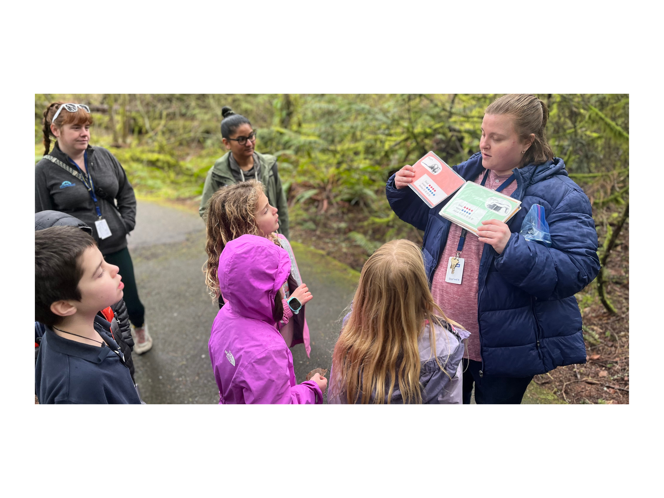 Elementary students out on the trail at Tualatin Hills Nature Park getting ready to start a hands-on activity to learn about habitats. 